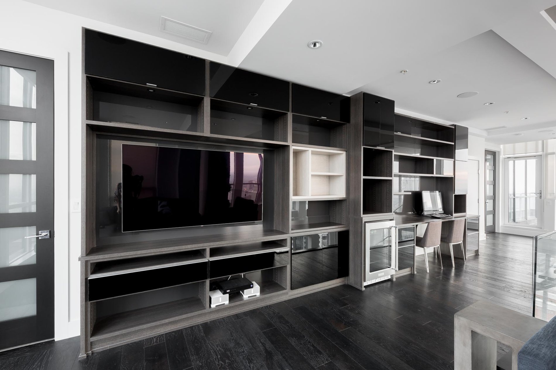 Dark and Cozy Media and Office Unit Dark and cozy media center with open and closed shelving, a desk, and a mini fridge