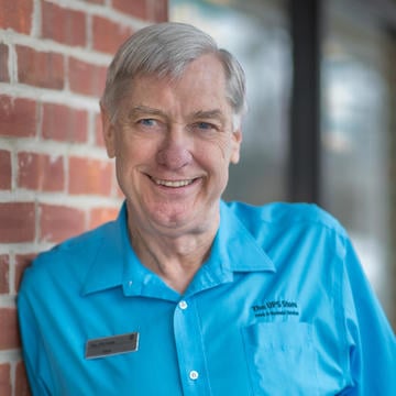 franchisee standing in blue shirt outside store