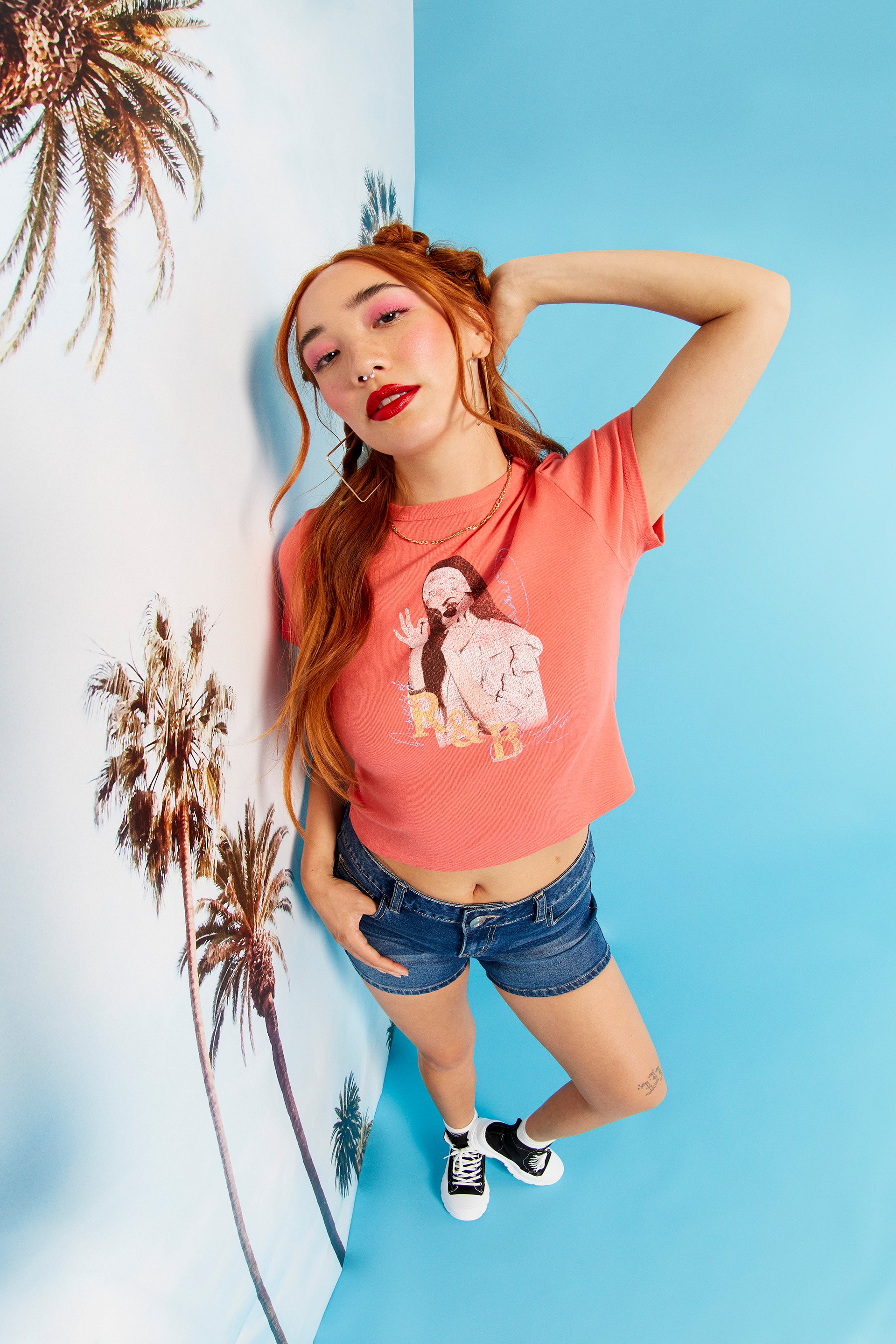 A female model wearing jean shorts and a graphic tee from rue21