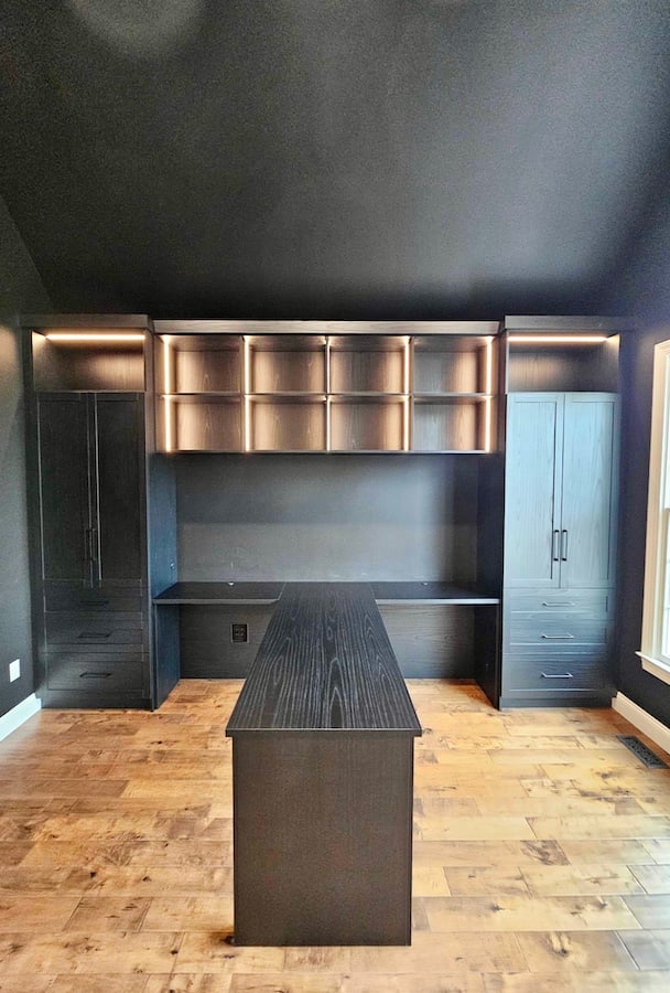 Sleek Home Office Desk Custom home office desk with a dark brown countertop, shelving, drawers, integrated lighting, and a penisula