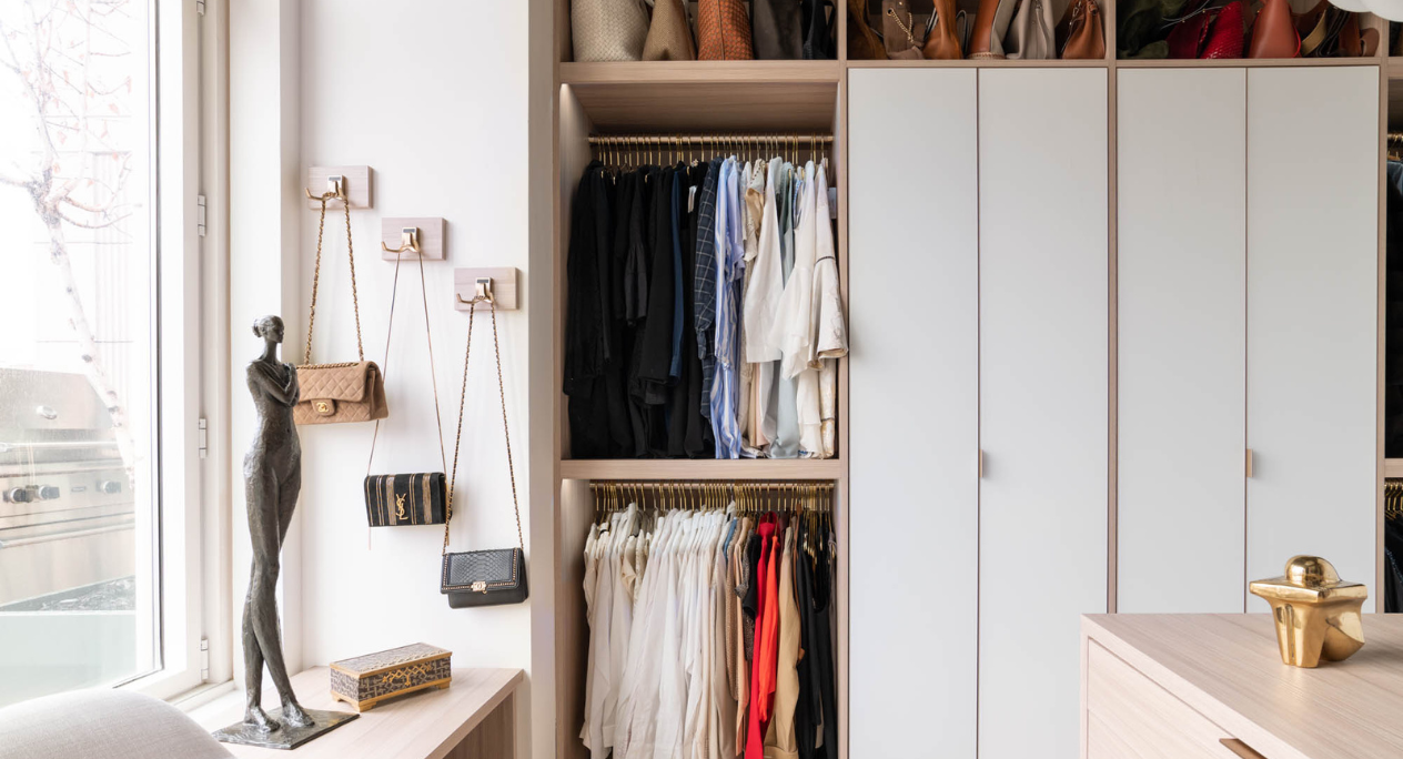 Contemporary Walk-in Closet full room walk-in closet with open and closed cabinetry white & natural wood combo with island in center and dedicated jewelry drawer storage New York, NY