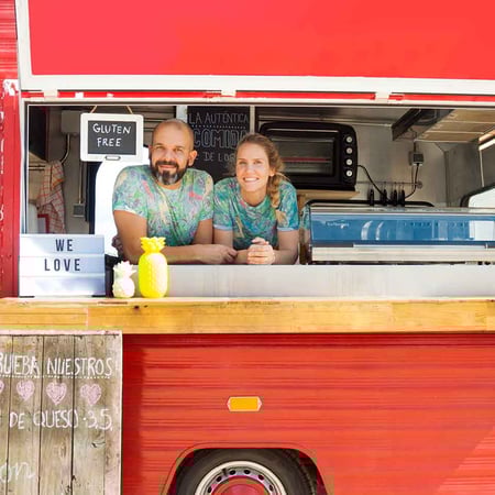 a couple running their food truck on a sunny day