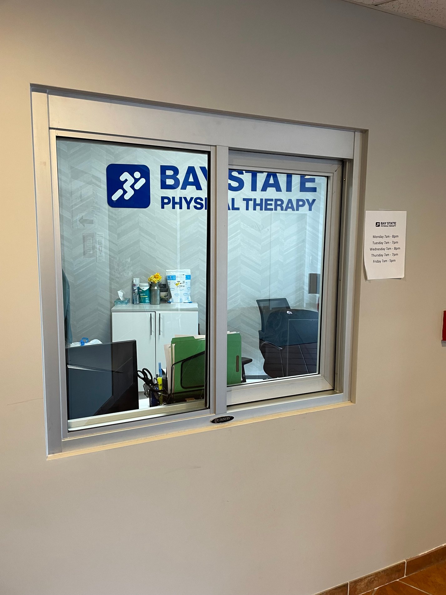 Bay State Physical Therapy Blue Logo on patient check-in window in Kingston MA