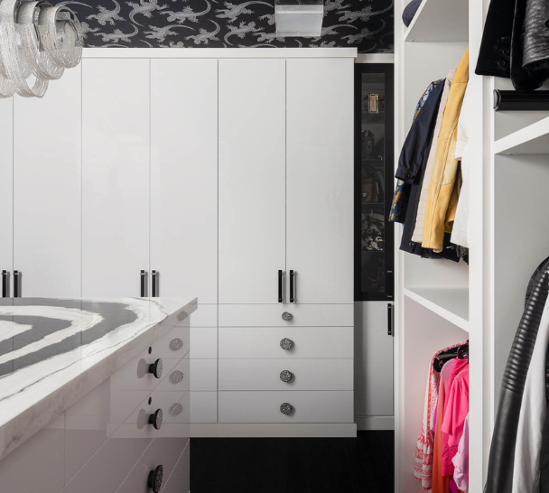 Streamlined Black & White Walk-in Closet white full-room walk-in closet with black hardware, black and white closet, closed cabinetry doors, open hanging space, drawers, center island with black & white marble countertop Dutchess NY