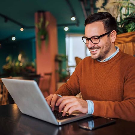Man sitting and typing on a laptop computer