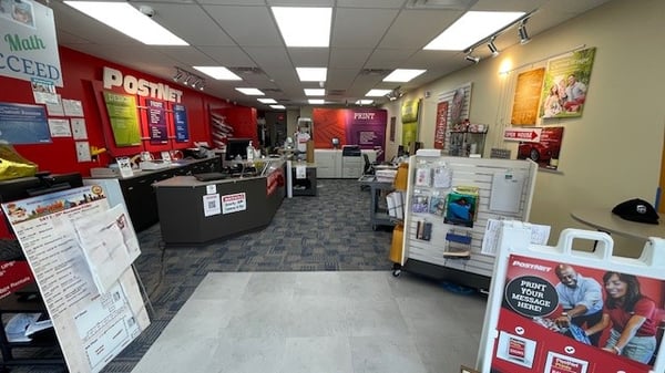 Inside view of PostNet Katy showing an a-frame sign, canvas print samples, shipping and packaging materials, and more.