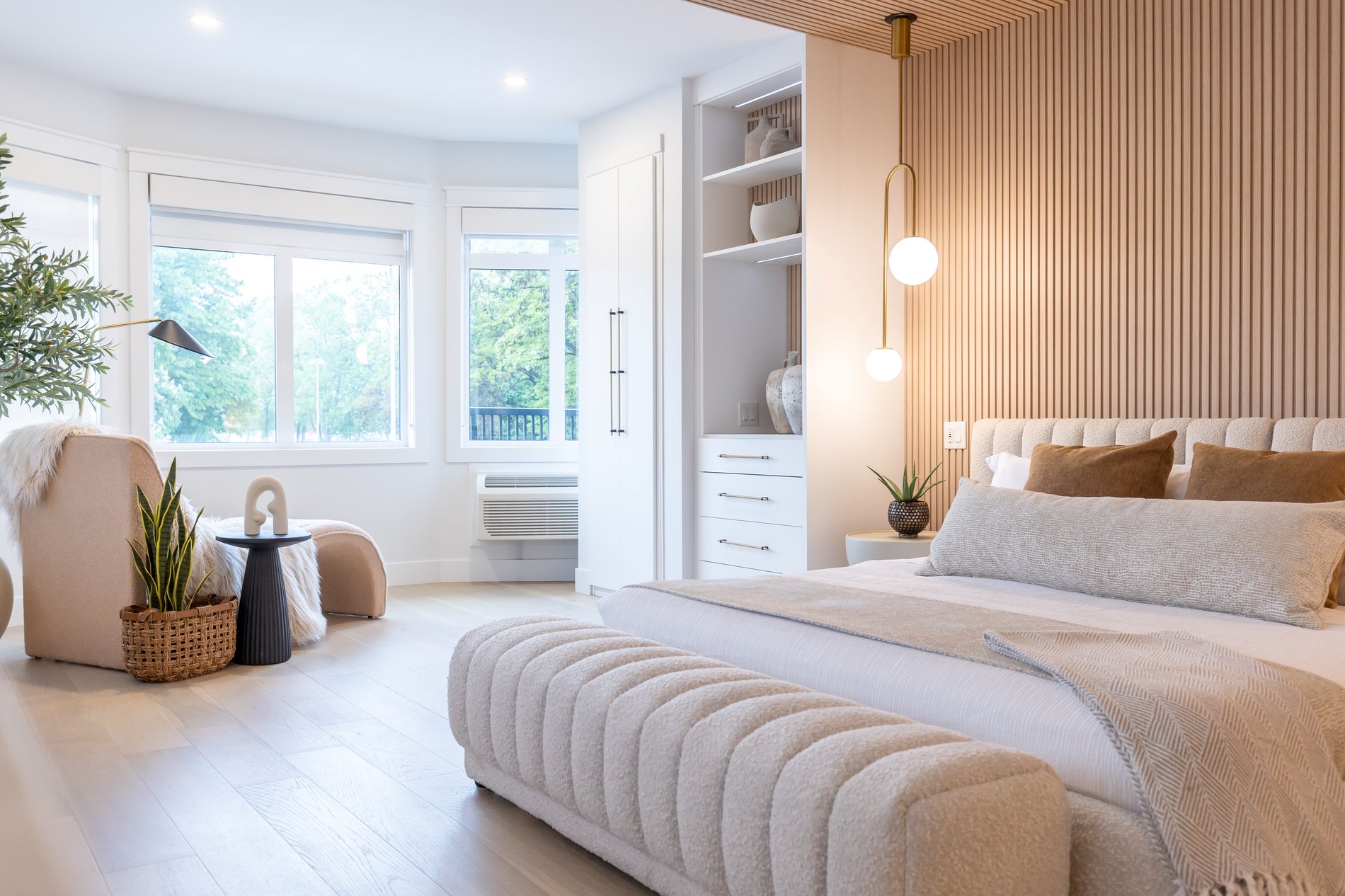 Luxe hotel room with a view Modern hotelroom with slat walls, kingsize bed, comfortable chair and built in white closets with drawers