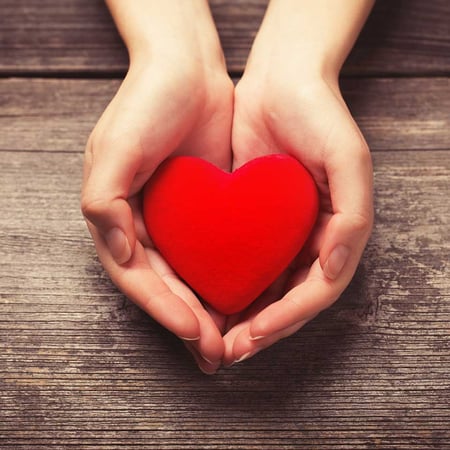 hands holding a red fabric heart