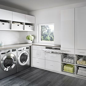 Improve your home with these 5 organization tips Custom white cabinets for storage in large laundry room by California Closets Columbus, Ohio.