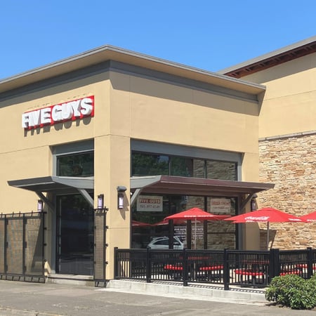 Exterior photograph of the entrance to the Five Guys restaurant at 495 West 7th Avenue in Eugene, Oregon.