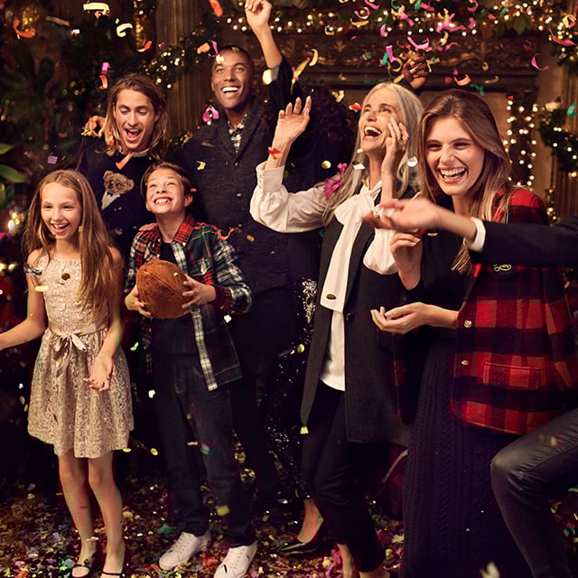 Family standing together cheering as confetti falls.