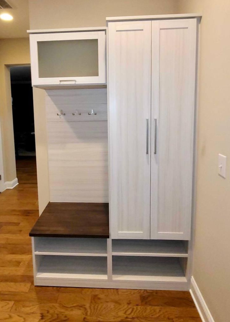 Entryway Storage with a Polished Finish An entryway closet, designed with hooks, shelves, and a frosted cabinet.