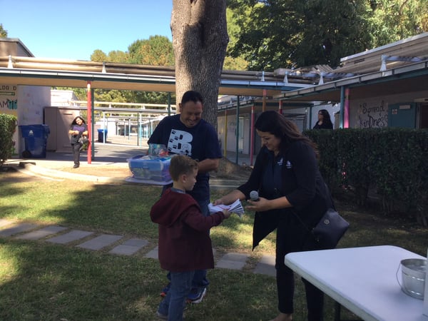 Person giving an item to a kid