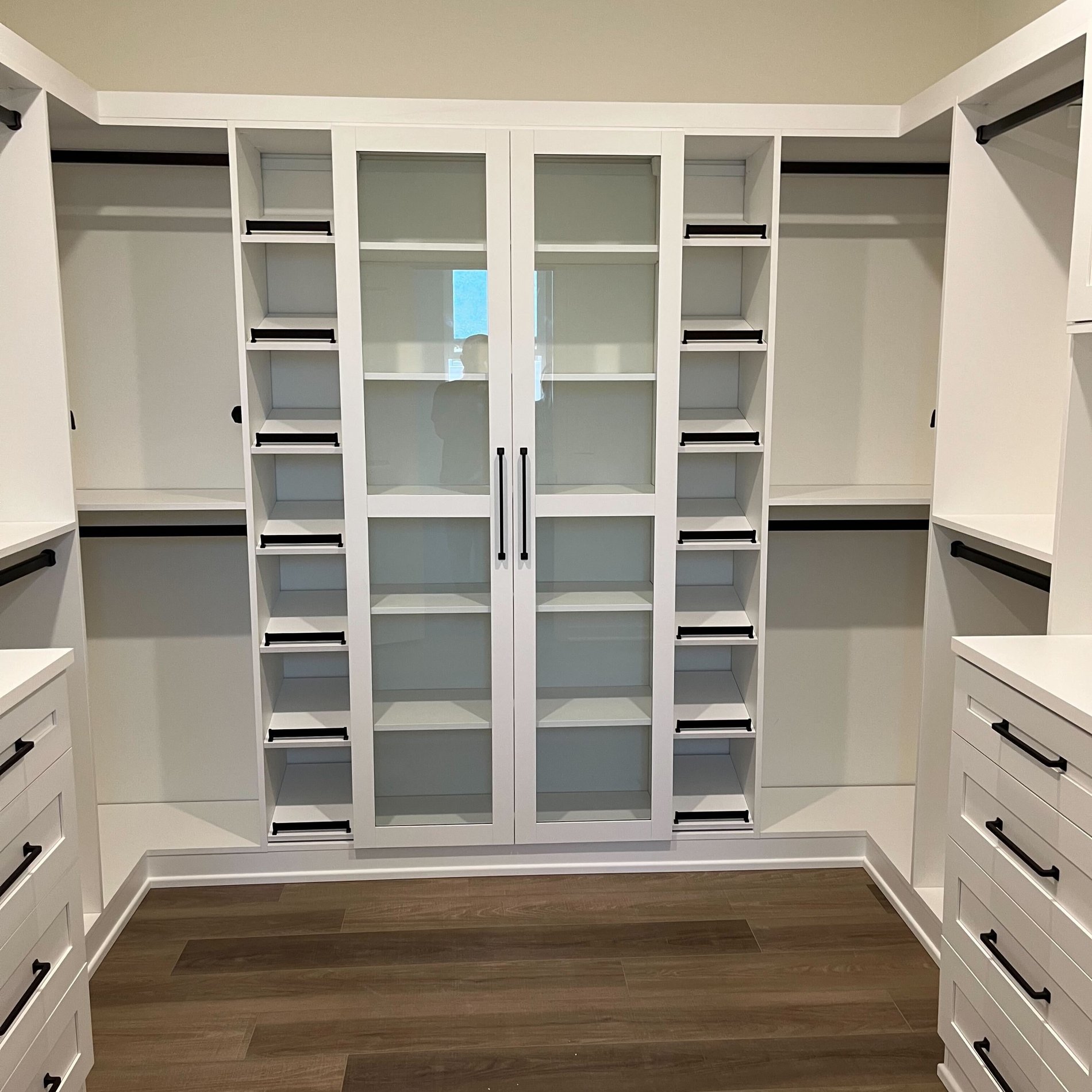 White closet shelving with plenty of shoe storage White walk-in closet with black accents