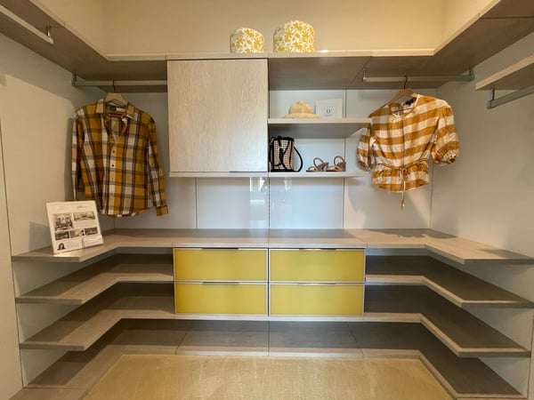 Clean Simple Lines standout in this modern walk in closet with pops of yellow accents by California Closets San Diego, California. Neutral walk-in closet with lighting, storage, and bench by California Closets San Diego, California.