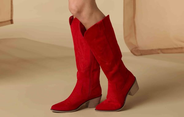 Woman is wearing tall red cowboy boots.