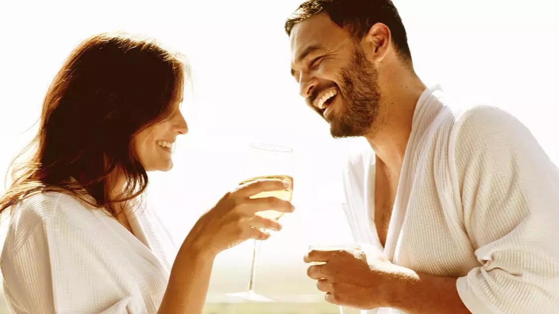 couple in spa robes sipping wine