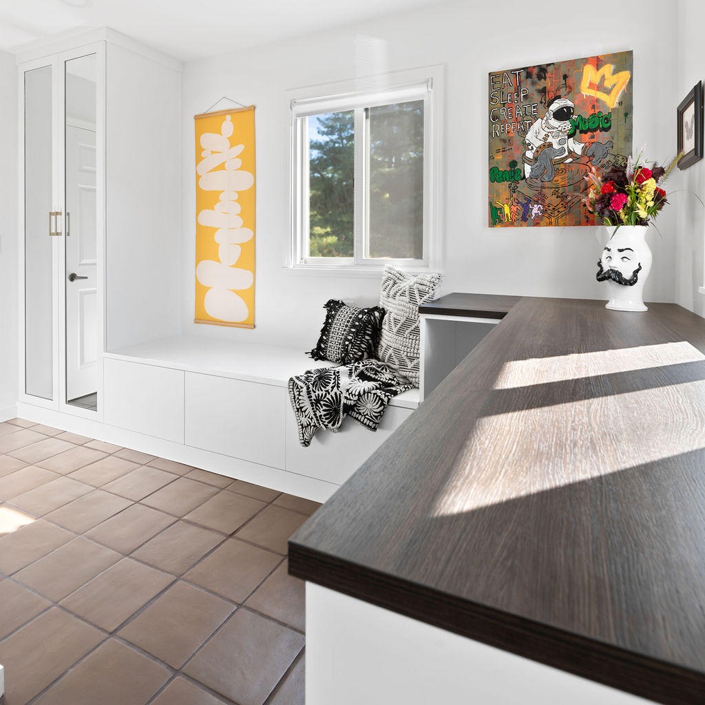 Walk-In Mudroom Mudroom with a Bench, mirrored doors and a countertop by California Closets Northern Michigan