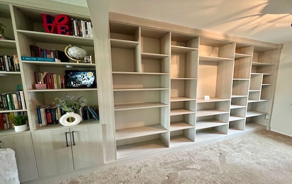 Custom Library Light wood wall unit with built-in bookshelf shelving and custom cabinets for organized storage and display in Livonia, Michigan
