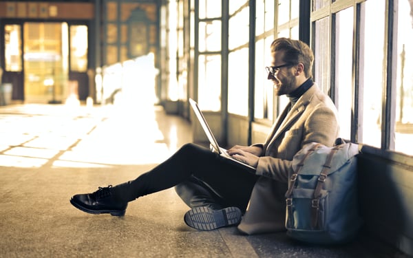 Mann im Flughafen bei der Onlineberatung