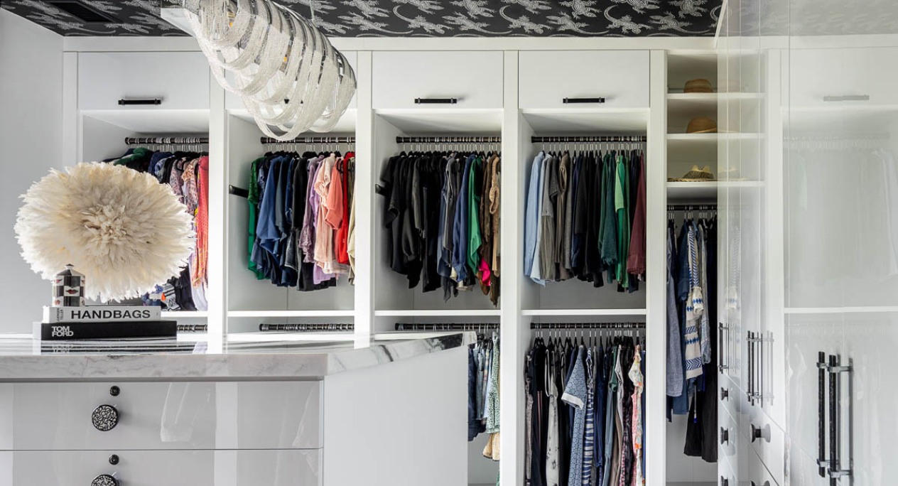 Luxury Black & White Walk-in Closet white full-room walk-in closet with black hardware, black and white closet, closed cabinetry doors, open hanging space, drawers, center island with black & white marble countertop Dutchess NY