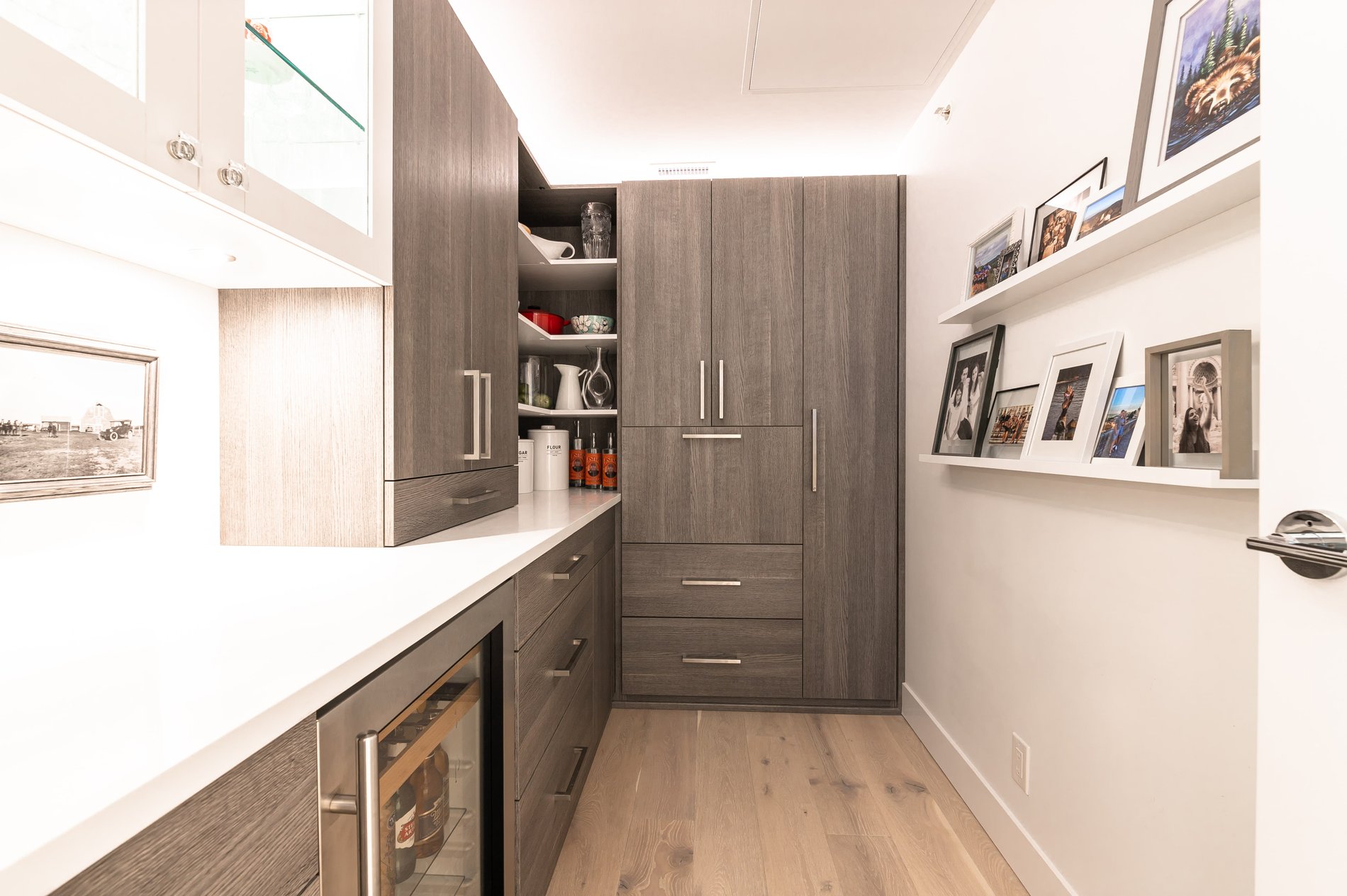 Bright pantry with wood tones Wood tone pantry with white acrylic countertops and floating shelves