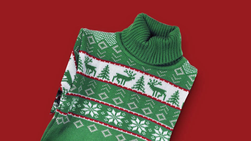 An ugly holiday turtleneck sweater with pine trees and reindeer