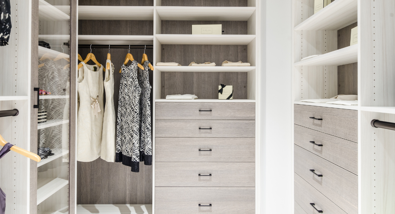 Two-Toned Walk-in Closet California Closets Hudson Valley NY Walk-in Closet in White and Gray with Hanging Drawers Shelving and Clear Glass Doors to Display Purses