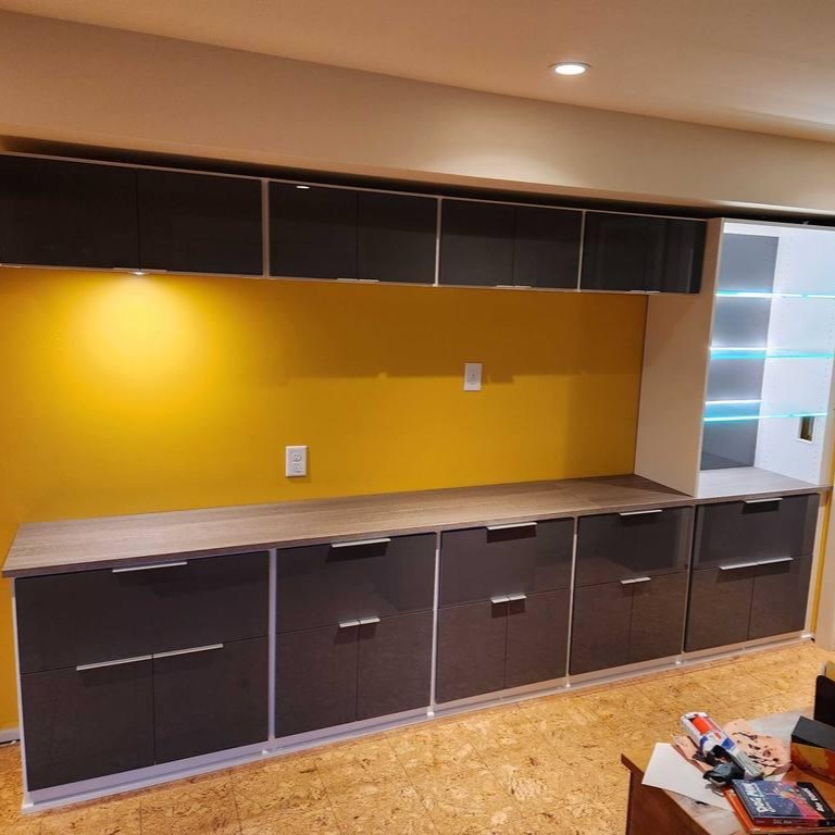 Bold Cabinets with a Splash of Color Brown cabinets set against a vibrant yellow accent wall.