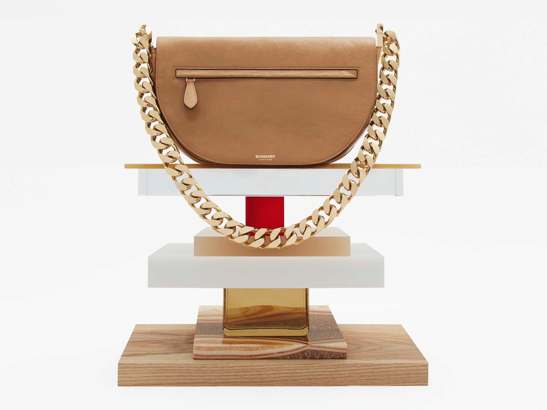 Warm sand mini Burberry Olympia zip bag on tiered platform.