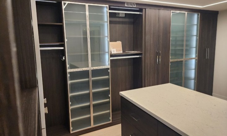 Primary Walk-In Closet Walk-in closet with glass doors and shoe storage