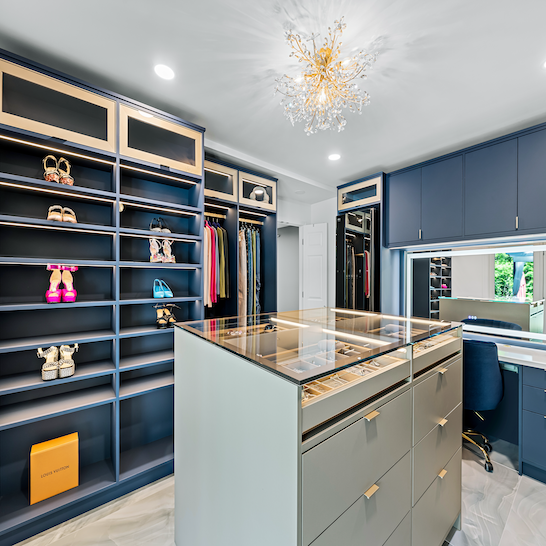 Custom Dressing Room with Integrated Lighting walk in closet with lighting, shoe space, and an island