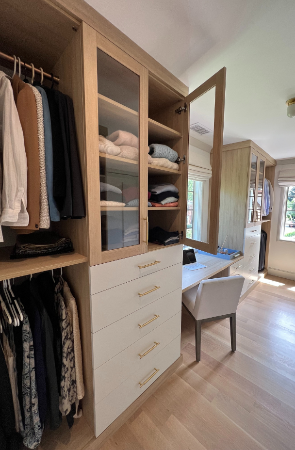 Multi-functional Cloffice Img 8 California Closets Westchester NY White and Natural Wood Custom Closet and Workspace area with Drawers, Double Hanging to maximize storage, Clear Glass Doors with Shelving and a Desk for workspace