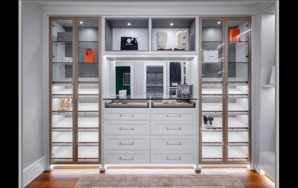 Luxury Dressing Room Custom walk in closet featuring illuminated display cabinets, shoe organization storage, integrated drawers, and custom closet systems. This walk in closet organization design combines custom closets, closet accessories storage, and elegant display space. California Closets Greater Detroit