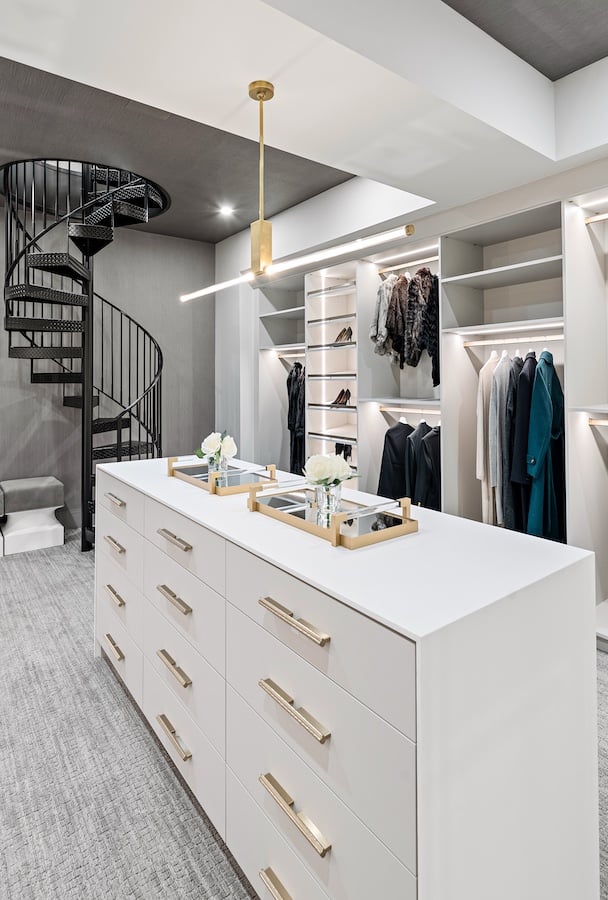 Sleek Modern Walk-in Closet Custom Built walk in closet with lighting under the cabinets and island by California Closets Greater Detroit, Michigan.