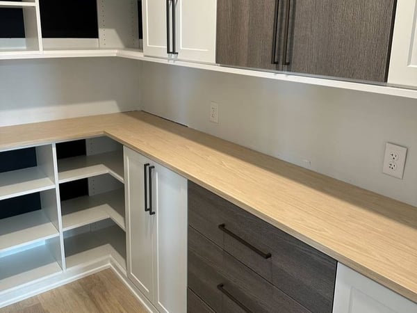 Contrast color pantry design with shelving, cabinets and wooden bench by California Closets Wilmington, North Carolina.