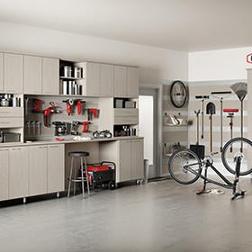 How to utilize your garage as an effective storage space Customized light grey cabinets with tool area in large garage by California Closets Missoula & Western Montana.