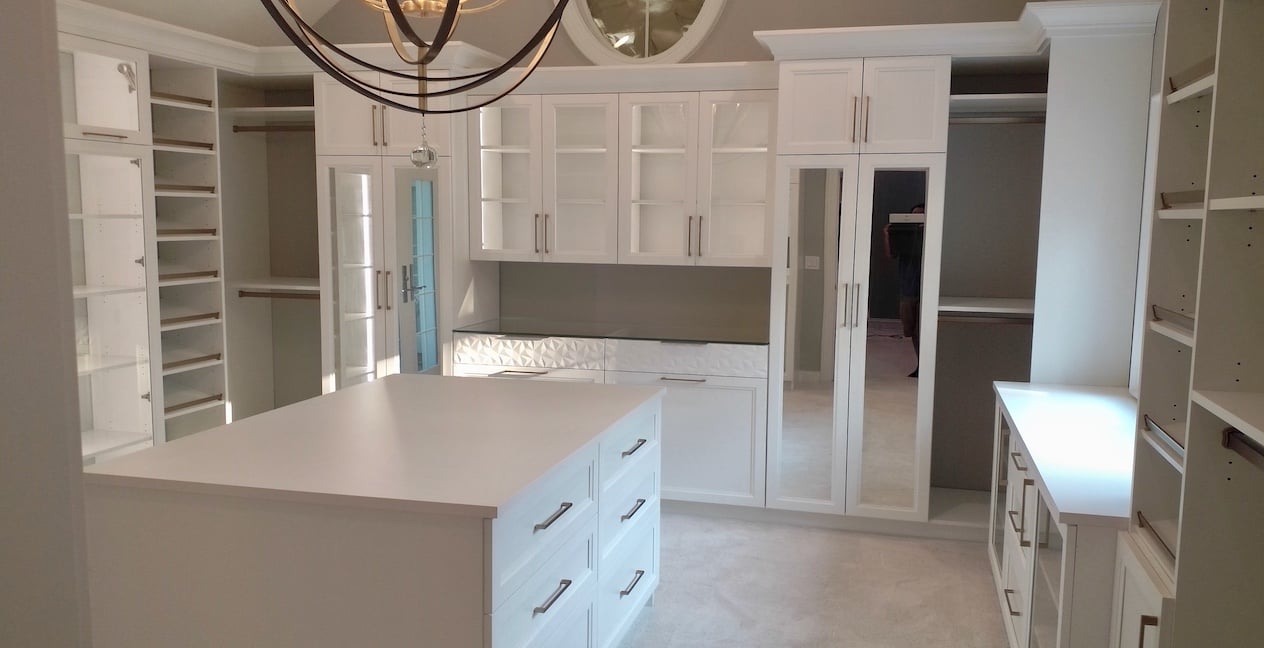 Walk in Closet White walk in closet with drawers, shelves, integrated lighting, hanging space and an island