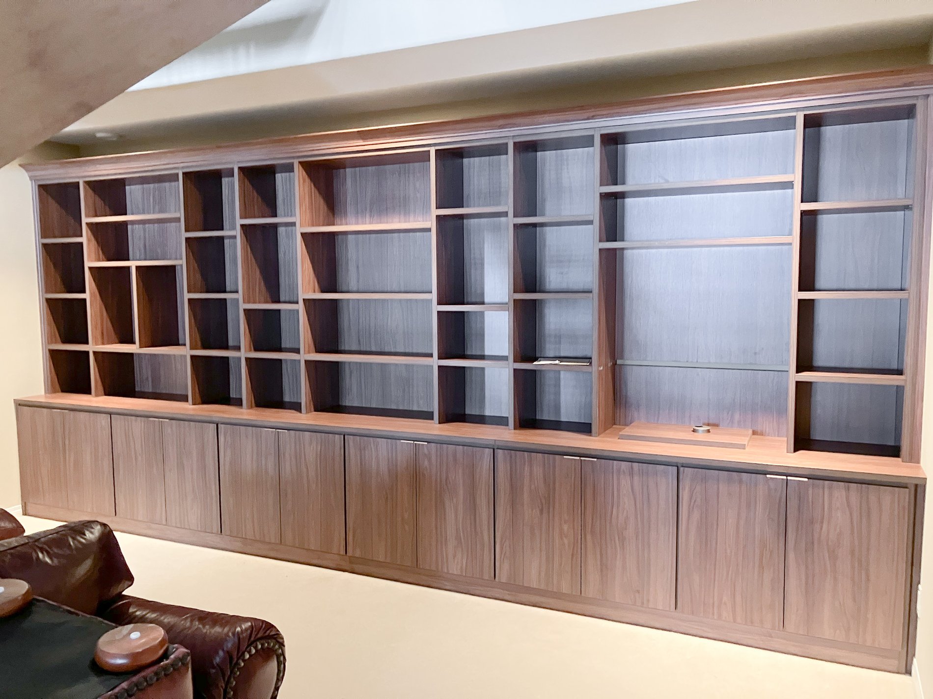 Traditional Library Custom bookcase with open shelving and closed storage in a reddish brown finish.