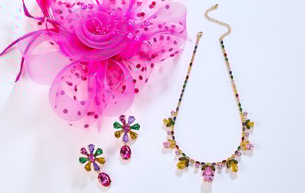 A pink fascinator, pink drop earrings and floral jeweled necklace are displayed on a white background.