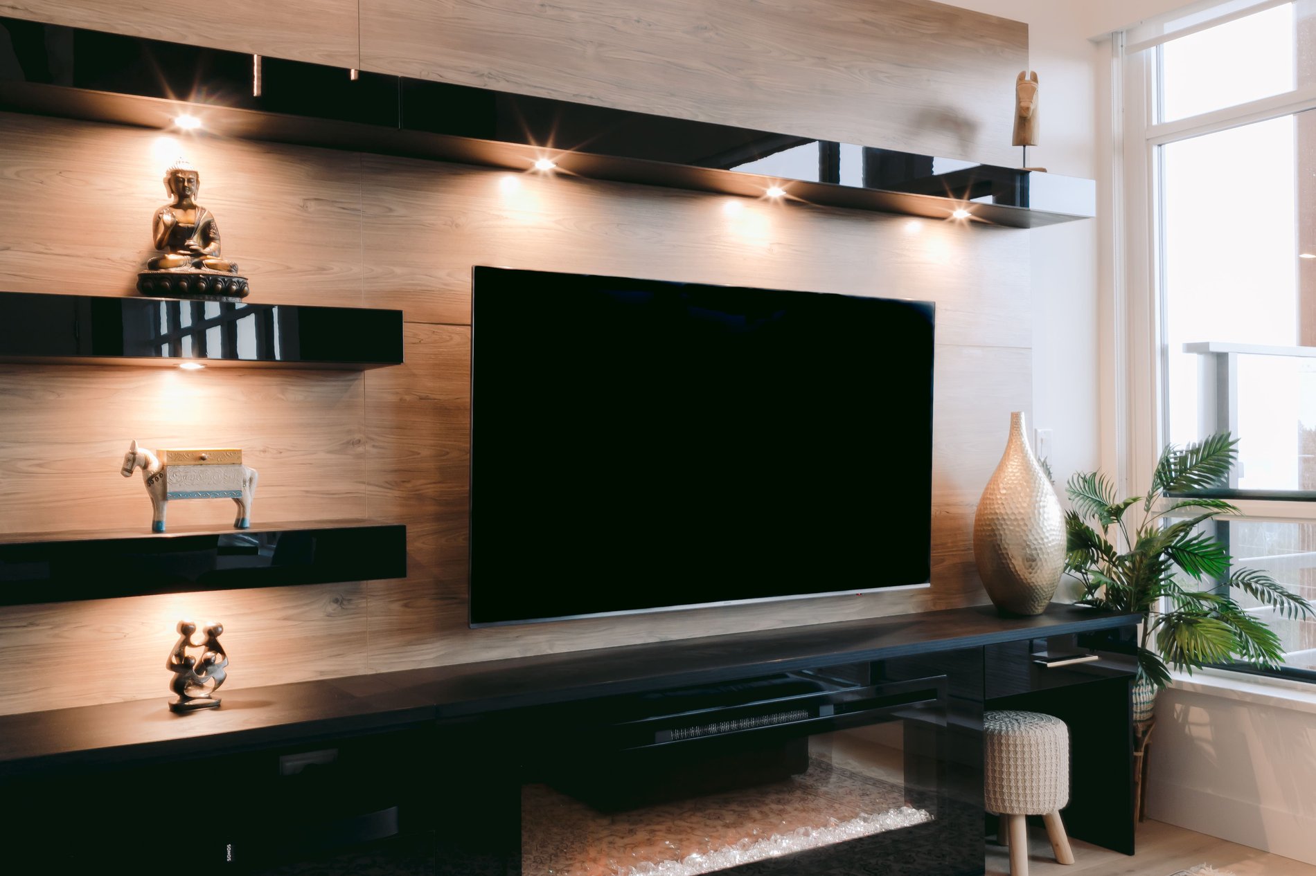 Glossy black media unit Photo of media unit with full view of TV and undermount lighting