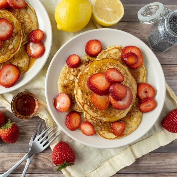 lemon poppy seed pancakes with strawberries and maple syrup