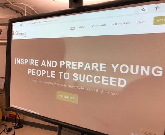 A photo of a projector screen displaying a slideshow.