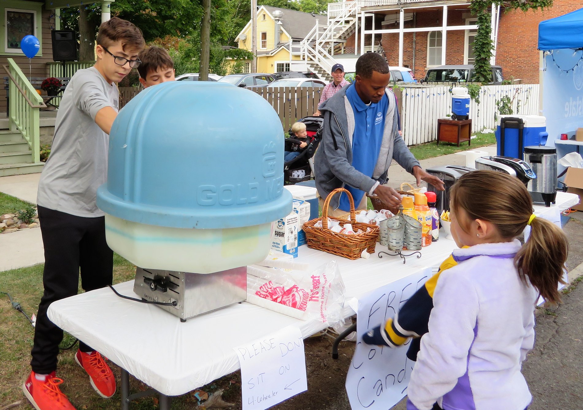 Staff member Kynell Martin helps hand out coffee and cotton candy at Fall Fest 2018.