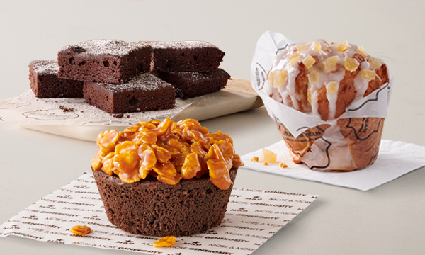 Freshly baked treats from Mugg & Bean On-The-Move, including a Citrus & Ginger Giant Muffin, Gingerbread Loaf Cake, and a chocolate brownie Sweet Square.