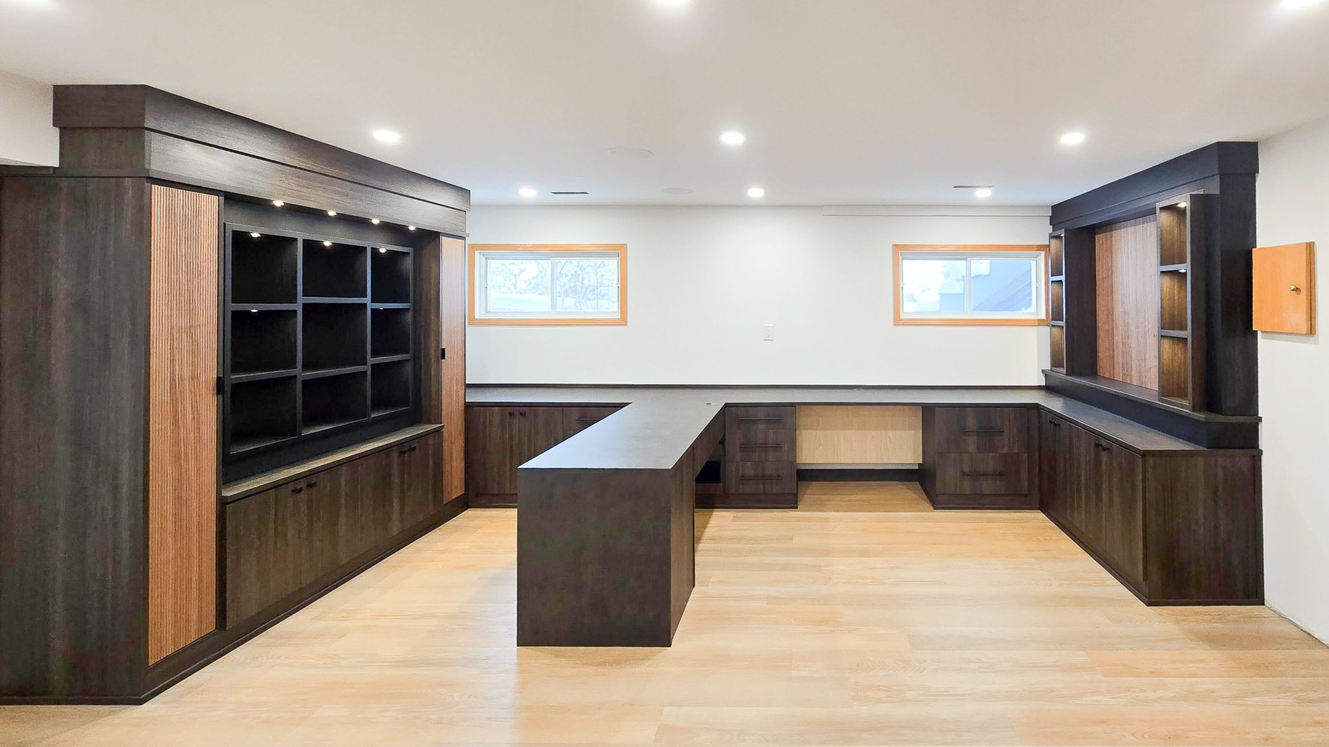 Modern and Dark Home Office This home office allows for a few different work stations, plenty of closed shelving, and open shelving. Texture door fronts adds extra visible interest.