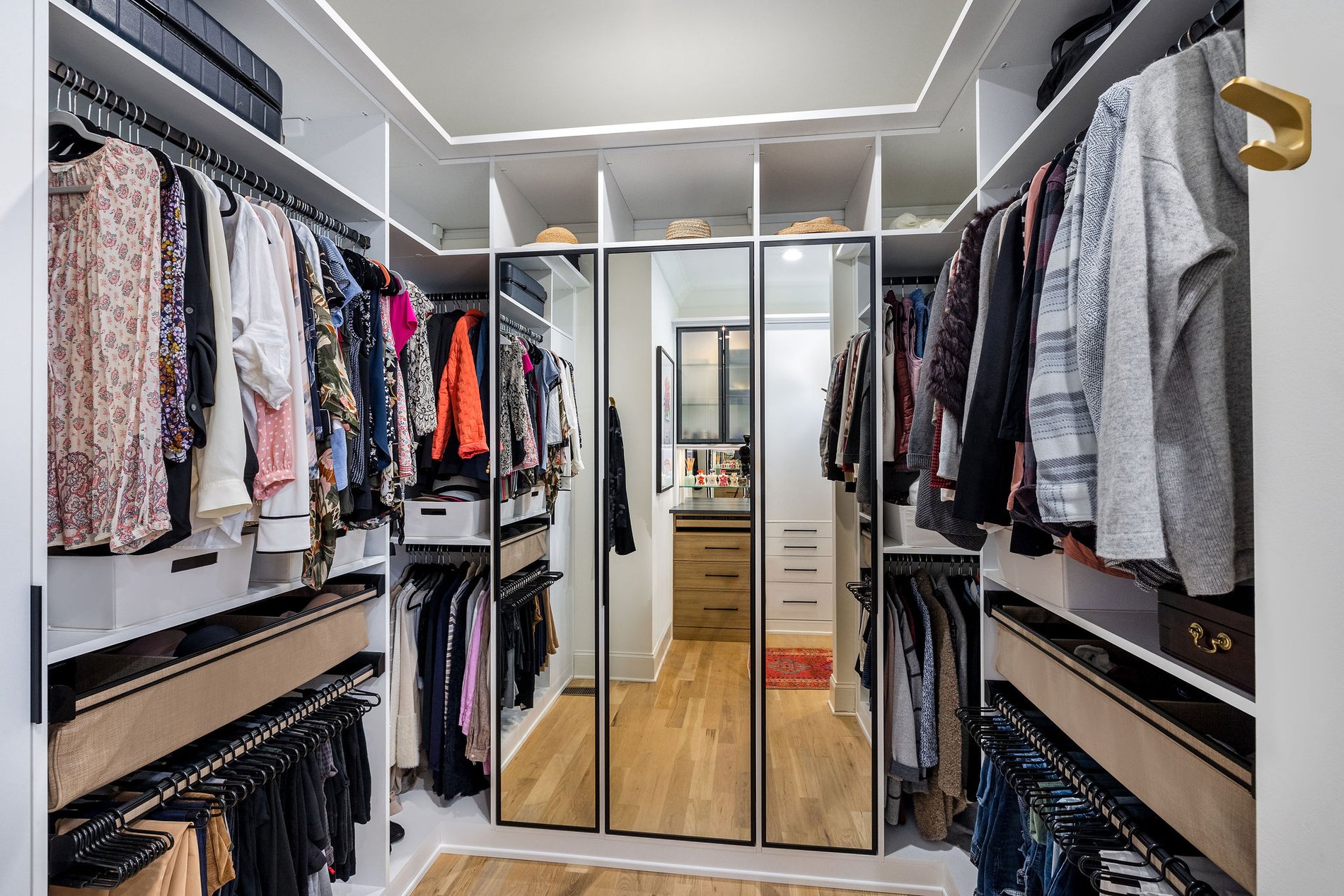 Custom Walk-in Closet | California Closets Nashville Walk-in closet with mirrored wardrobe, hanging clothes, and shelves by California Closets Nashville, Tennessee.