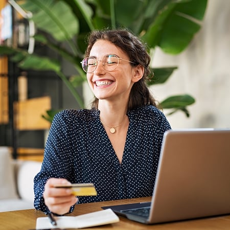 A woman holding a credit card and smiling