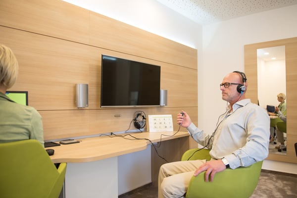 Kunde beim Hörtest in der Hörkabine