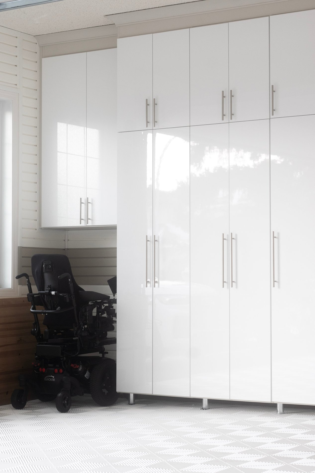 Sleek White Garage Cabinetry White garage floor to ceiling cabinets with high gloss fronts and white floor tiles.